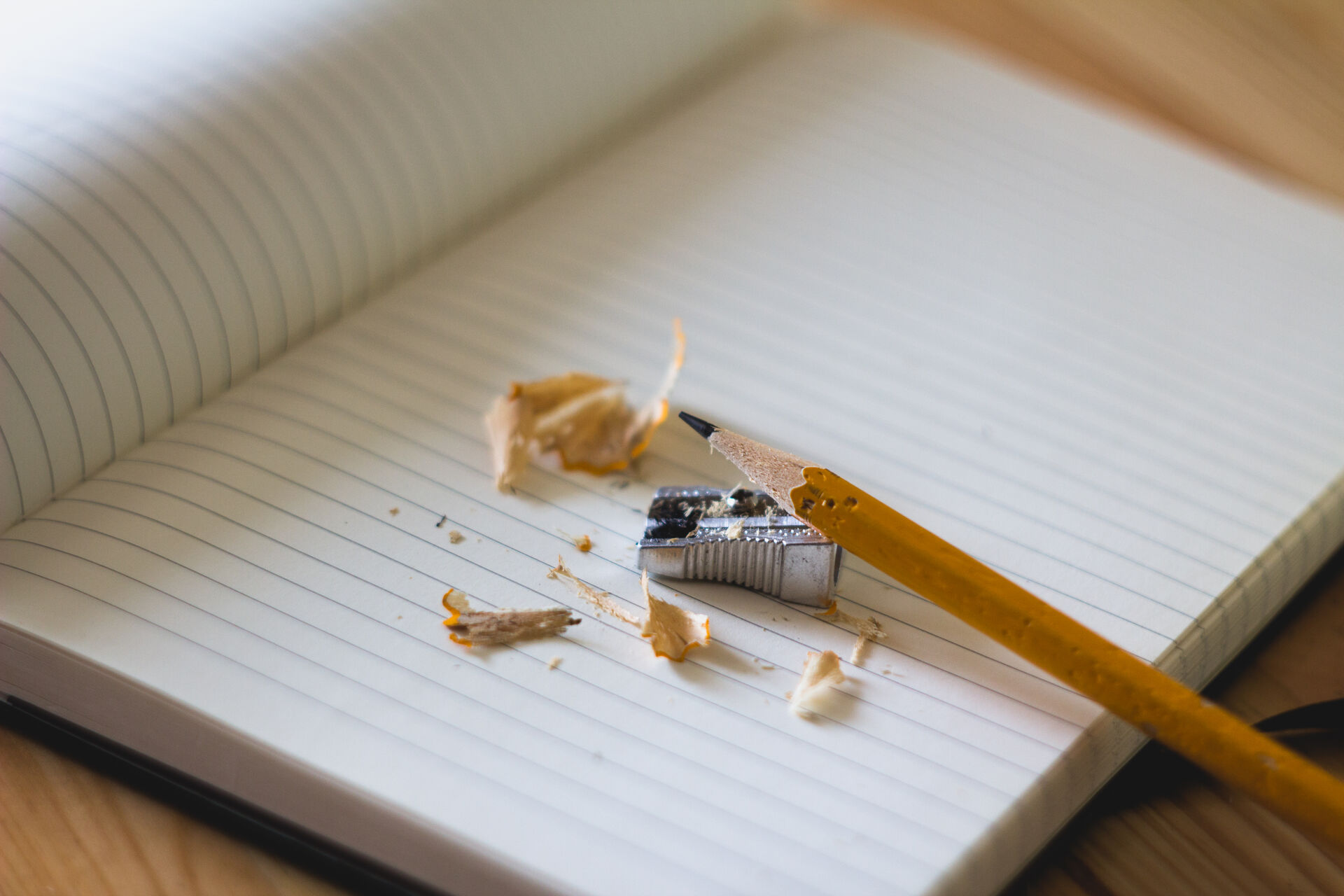 Pencil, sharpener and shavings on a lined notebook