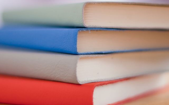 Stack of hardcover notebooks on a timber table